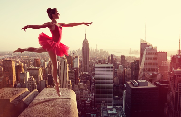 Eine Ballerina tanzt auf einem Hausdach